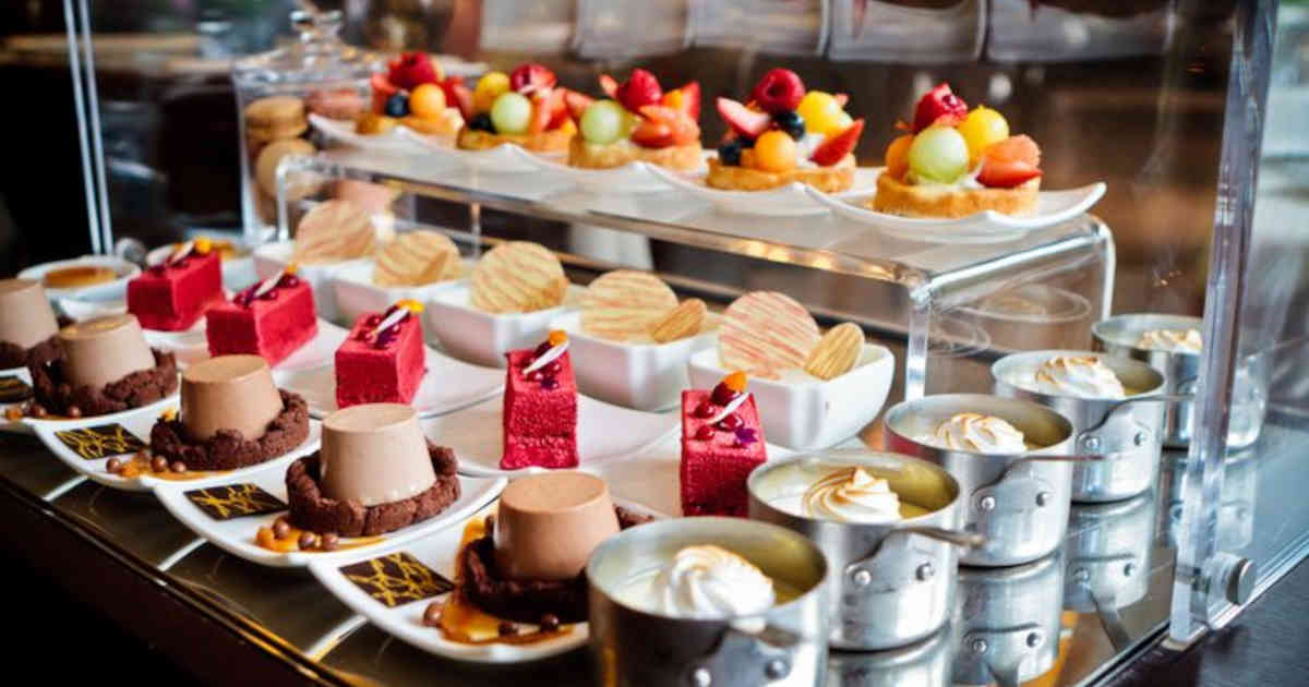 A dessert trolley full of cakes and fruit